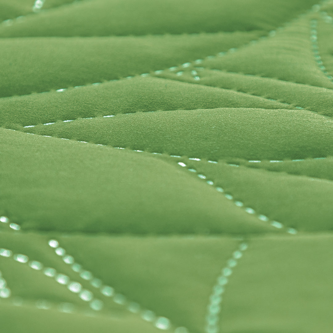 El Juego de Edredón Citrico es un hermoso juego de tonos verdes con un diseño capitonado de hojas.